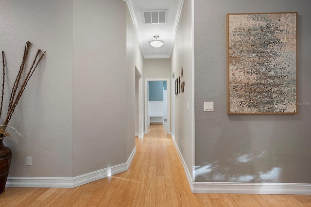 hallway with crown molding and light hardwood / wood-style flooring