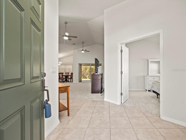 carpeted entrance foyer featuring ceiling fan and lofted ceiling