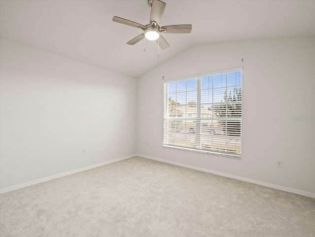 spare room featuring light carpet, ceiling fan, and vaulted ceiling