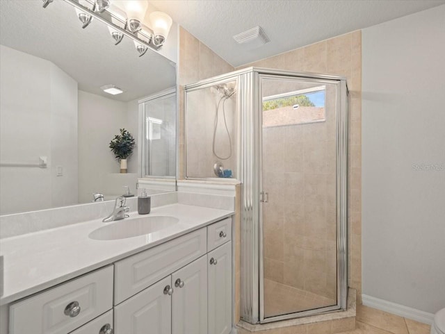 bathroom featuring a textured ceiling, vanity, tile patterned floors, and a shower with door