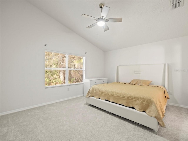 carpeted bedroom with ceiling fan and high vaulted ceiling