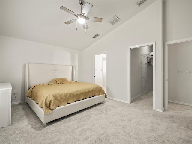 carpeted bedroom with ceiling fan, a walk in closet, high vaulted ceiling, and a closet