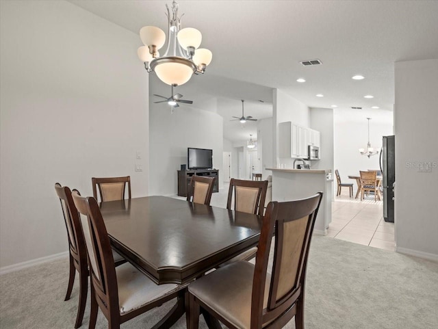 carpeted dining room with ceiling fan with notable chandelier