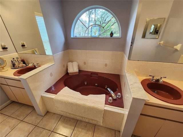 bathroom featuring tile patterned floors, tiled tub, and vanity