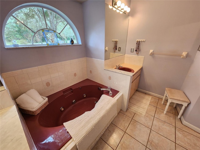 bathroom with tile patterned flooring, vanity, and a relaxing tiled tub