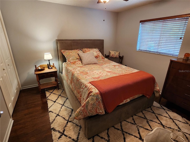 bedroom with ceiling fan, a closet, and dark wood-type flooring