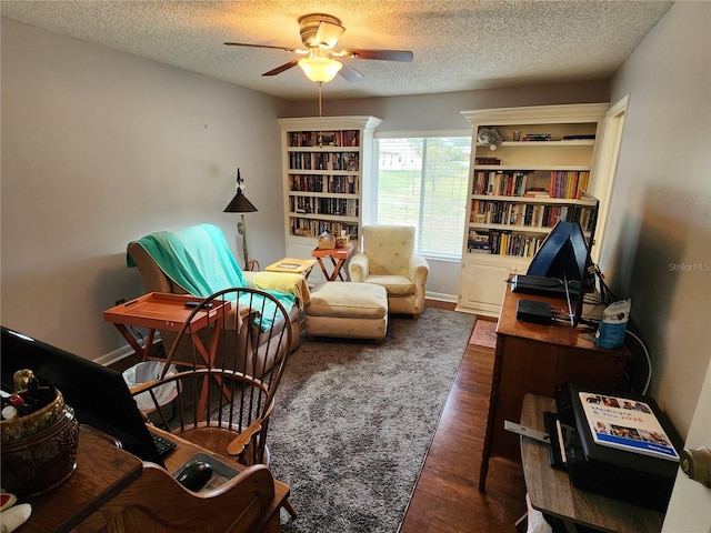 living area featuring a textured ceiling, ceiling fan, and dark wood-type flooring