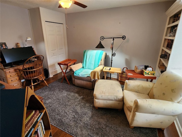 sitting room with ceiling fan and dark hardwood / wood-style flooring