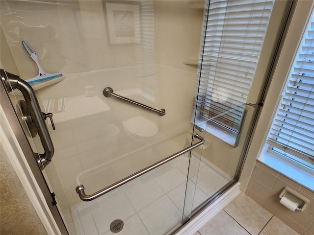 bathroom with tile patterned floors and a shower with door