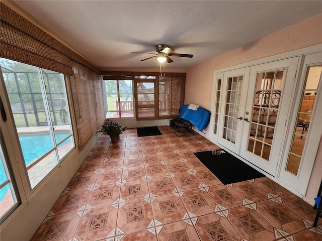 unfurnished sunroom featuring french doors, ceiling fan, and a healthy amount of sunlight