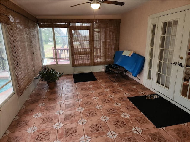 unfurnished sunroom with ceiling fan