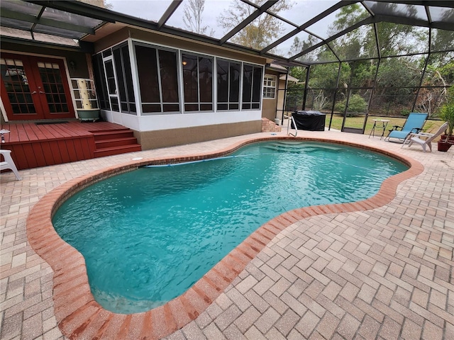 view of swimming pool with a lanai, a sunroom, french doors, and a patio