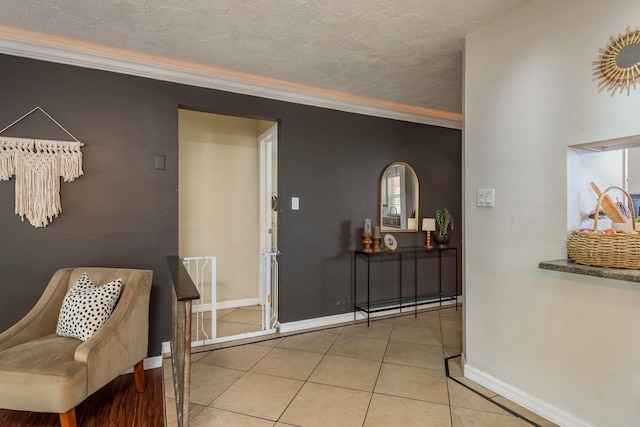 tiled entrance foyer featuring ornamental molding and a textured ceiling