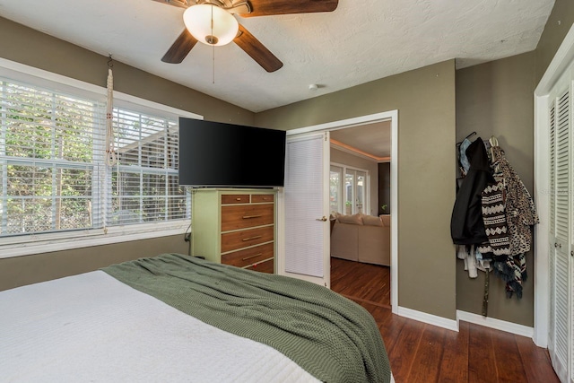 bedroom with a textured ceiling, a closet, ceiling fan, and dark hardwood / wood-style floors