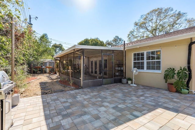 rear view of house featuring a patio area and a sunroom