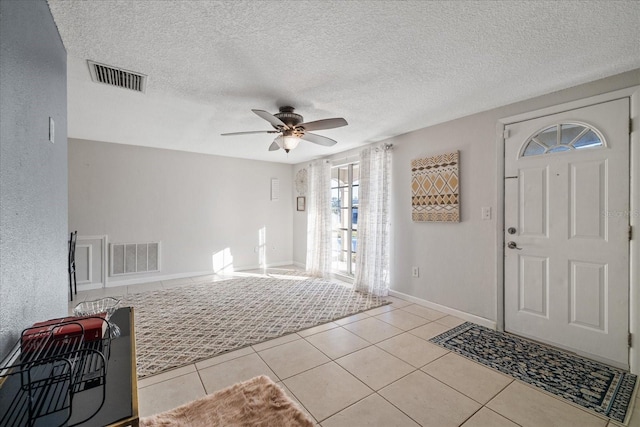 tiled entrance foyer featuring ceiling fan and a textured ceiling