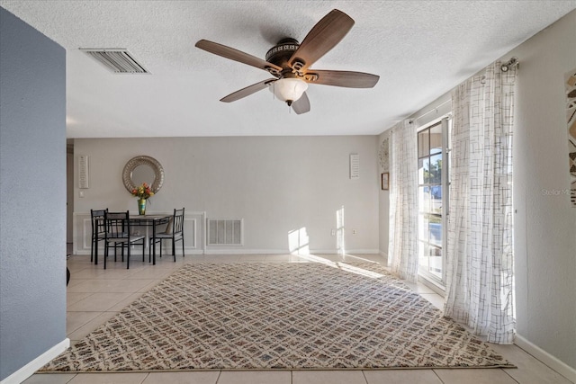 interior space featuring ceiling fan and a textured ceiling