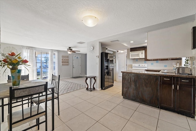 kitchen with stove, black fridge, dark brown cabinetry, a textured ceiling, and light tile patterned floors