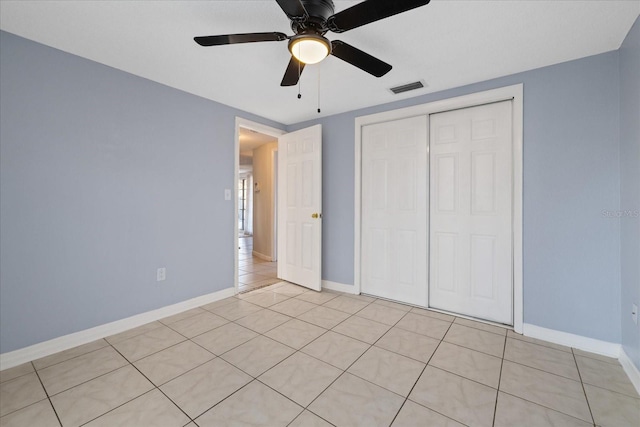 unfurnished bedroom featuring ceiling fan, a closet, and light tile patterned floors