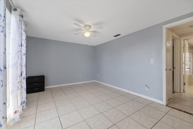 unfurnished room featuring ceiling fan and light tile patterned flooring