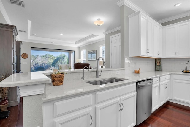 kitchen featuring kitchen peninsula, white cabinetry, sink, stainless steel dishwasher, and a tray ceiling