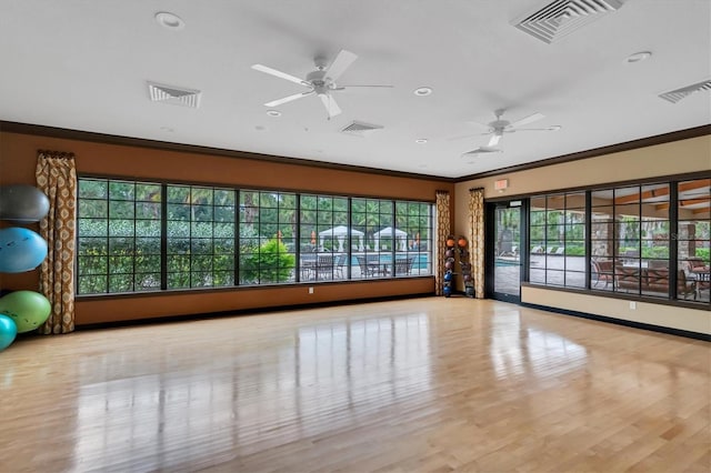 workout room featuring ceiling fan, ornamental molding, and light hardwood / wood-style floors