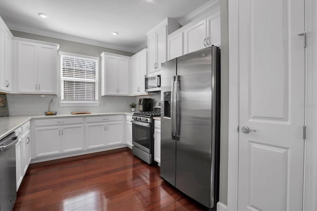 kitchen with decorative backsplash, dark hardwood / wood-style floors, white cabinets, and appliances with stainless steel finishes