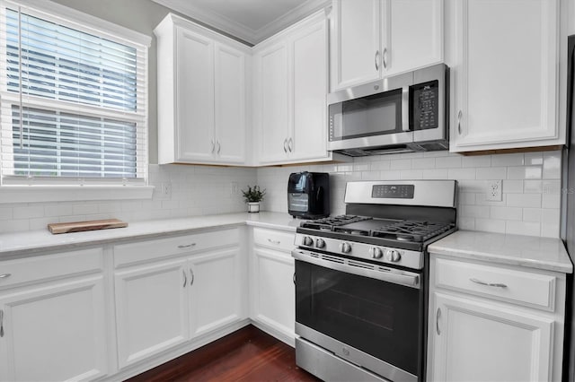 kitchen with stainless steel appliances, white cabinetry, dark hardwood / wood-style floors, and decorative backsplash