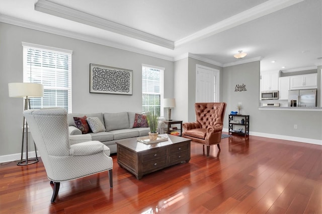 living area featuring a tray ceiling, dark wood-type flooring, and crown molding