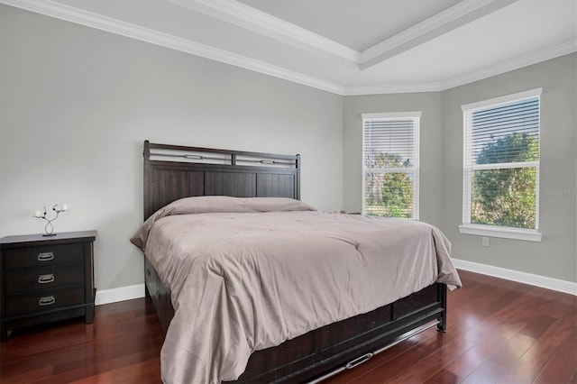 bedroom with dark wood finished floors, a raised ceiling, baseboards, and ornamental molding