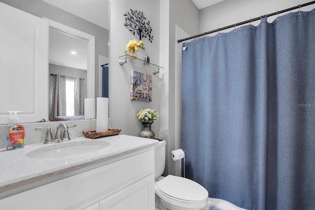 bathroom featuring vanity, curtained shower, and toilet