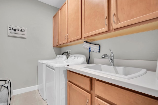 laundry room with baseboards, washing machine and dryer, light tile patterned floors, cabinet space, and a sink