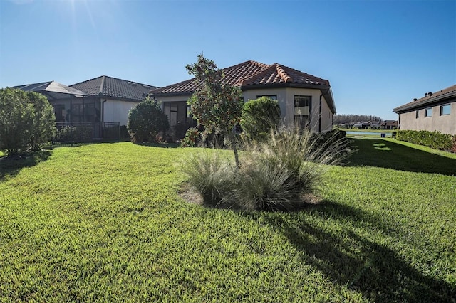 exterior space with stucco siding, a front yard, and a tile roof