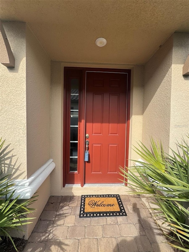 entrance to property featuring stucco siding