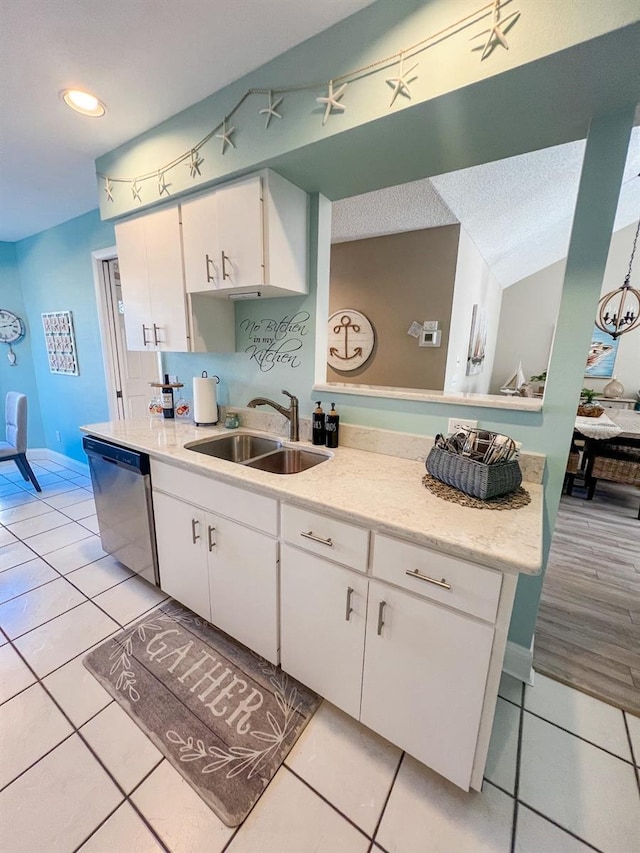 kitchen with white cabinetry, dishwasher, sink, a textured ceiling, and light tile patterned flooring