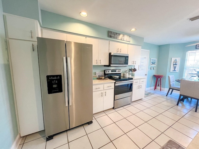 kitchen with white cabinetry, stainless steel appliances, and light tile patterned floors