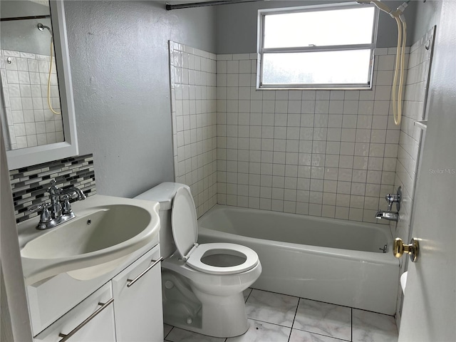 full bathroom with backsplash, vanity, tiled shower / bath combo, and toilet