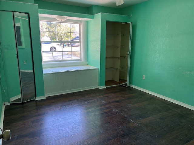 unfurnished bedroom featuring ceiling fan and dark hardwood / wood-style flooring