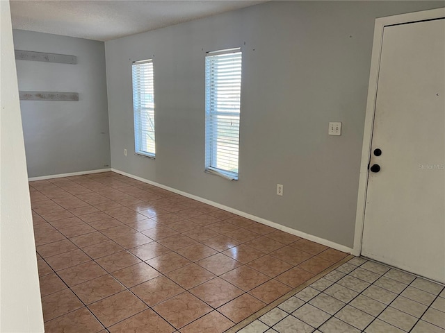 tiled spare room featuring a textured ceiling