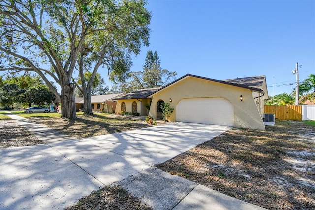 ranch-style home featuring a garage and central AC unit