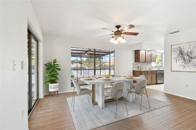 dining room featuring plenty of natural light, ceiling fan, and a textured ceiling