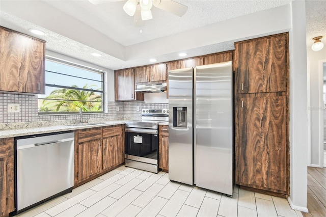 kitchen with backsplash, ceiling fan, sink, and stainless steel appliances