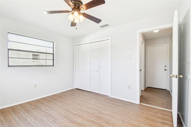 unfurnished bedroom with ceiling fan, a textured ceiling, and a closet