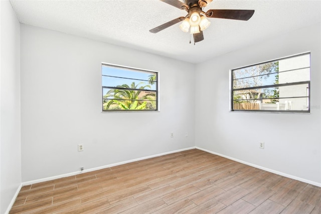 spare room featuring plenty of natural light, ceiling fan, and a textured ceiling