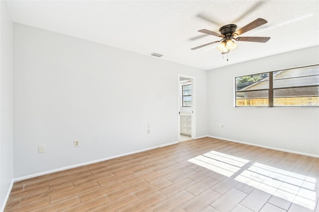 unfurnished room with ceiling fan and a textured ceiling