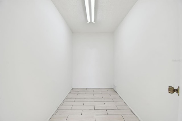 tiled spare room with a textured ceiling