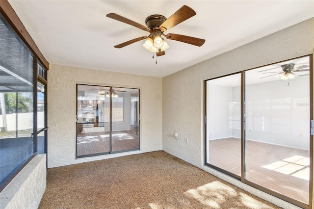 unfurnished sunroom featuring ceiling fan