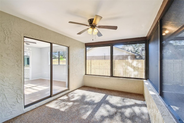 unfurnished sunroom featuring ceiling fan