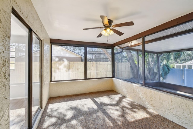 unfurnished sunroom with ceiling fan