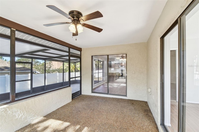 unfurnished sunroom with ceiling fan